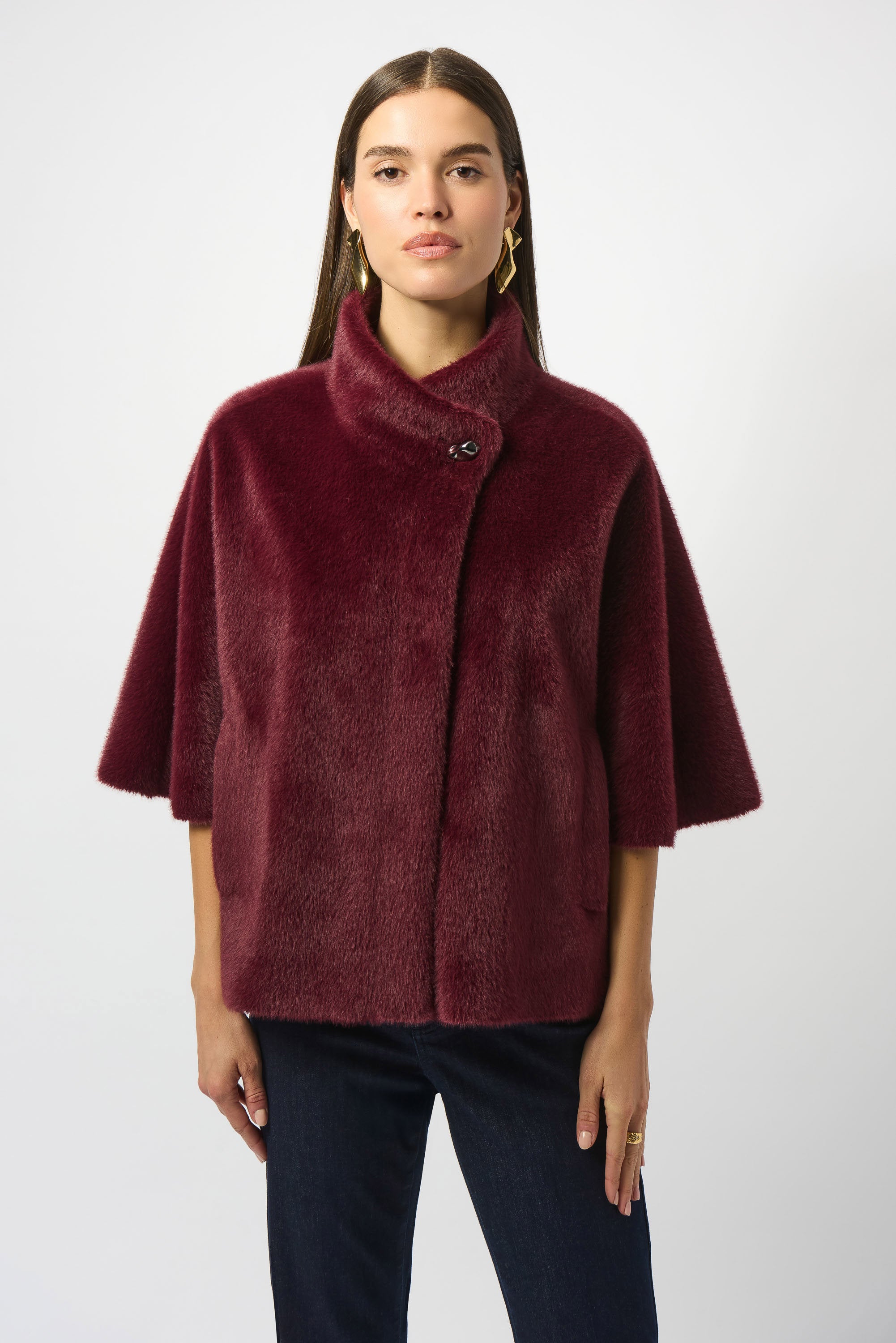 A model wearing a merlot-colored Joseph Ribkoff bonded faux fur suede jacket with a mock collar and snap front closure.